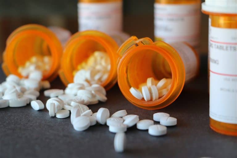 Background image of prescription medications dumped out on a countertop