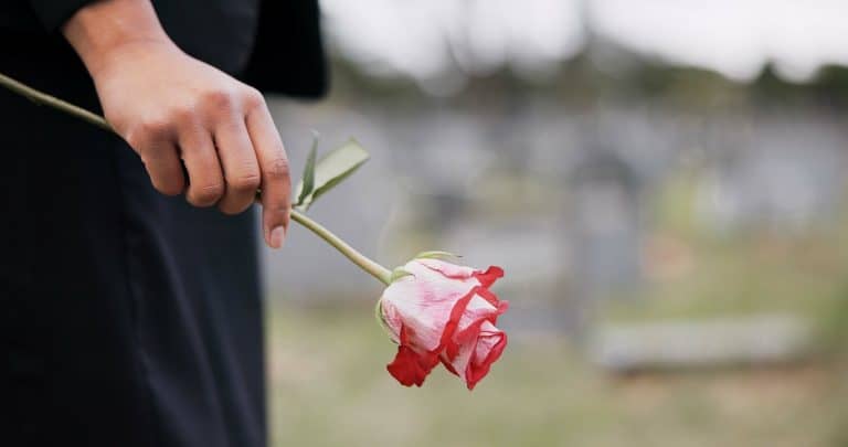 concept of grief, shot of a woman's hand holding a rose