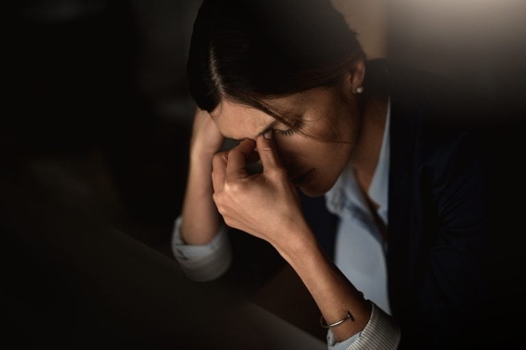 image of a woman looking stressed while sitting in an office, concept of stress and trauma